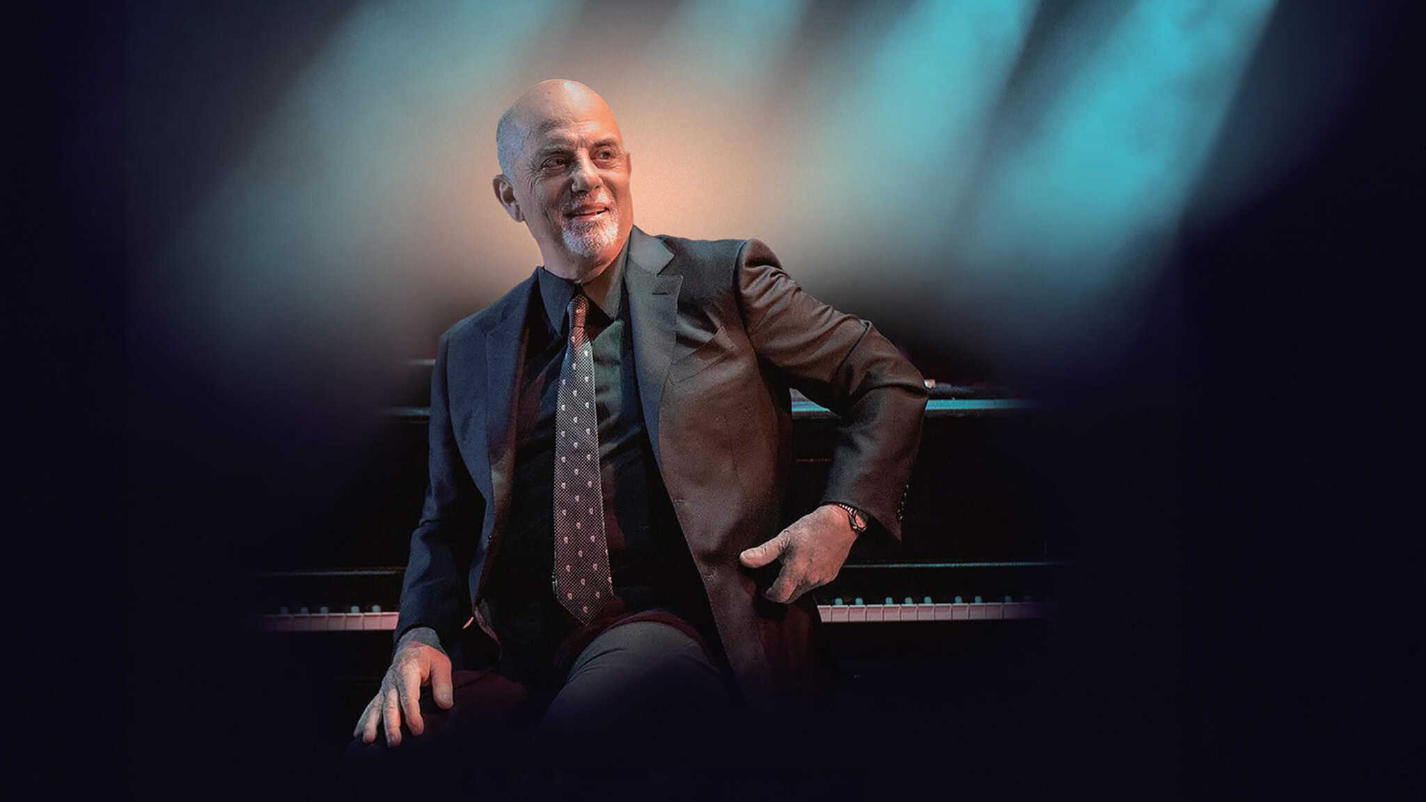 An older man in a suit is seated on a piano bench, smiling slightly, with dramatic lighting casting shadows around him, evoking a scene reminiscent of Billy Joel's intimate performances.