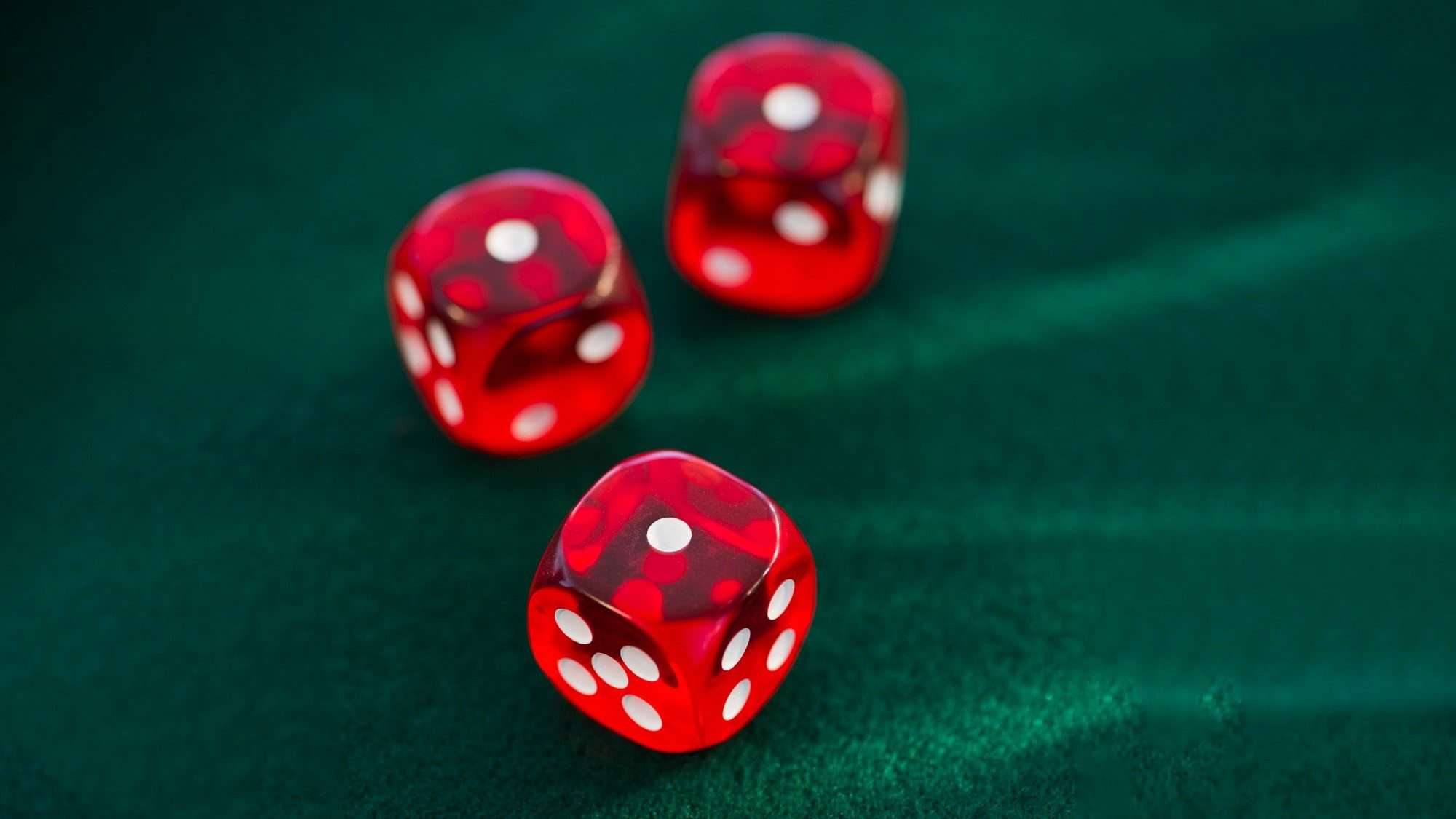 Red dice rolling on green felt