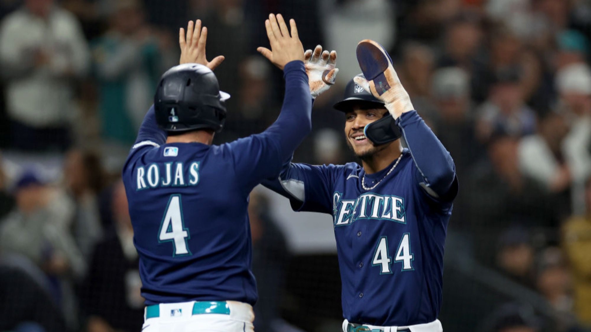 Two of the most popular baseball players in Seattle Mariners uniforms celebrating with a high-five.