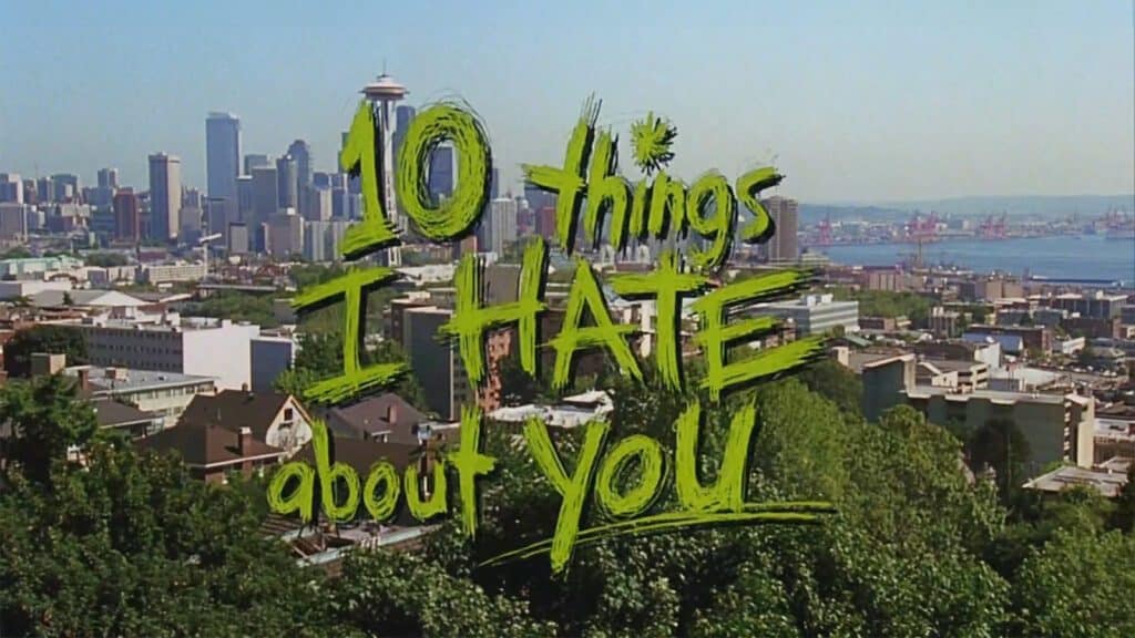 Title "10 Things I Hate About You Turns 25" superimposed in green graffiti style over a panoramic view of Seattle, featuring the Space Needle on the left.