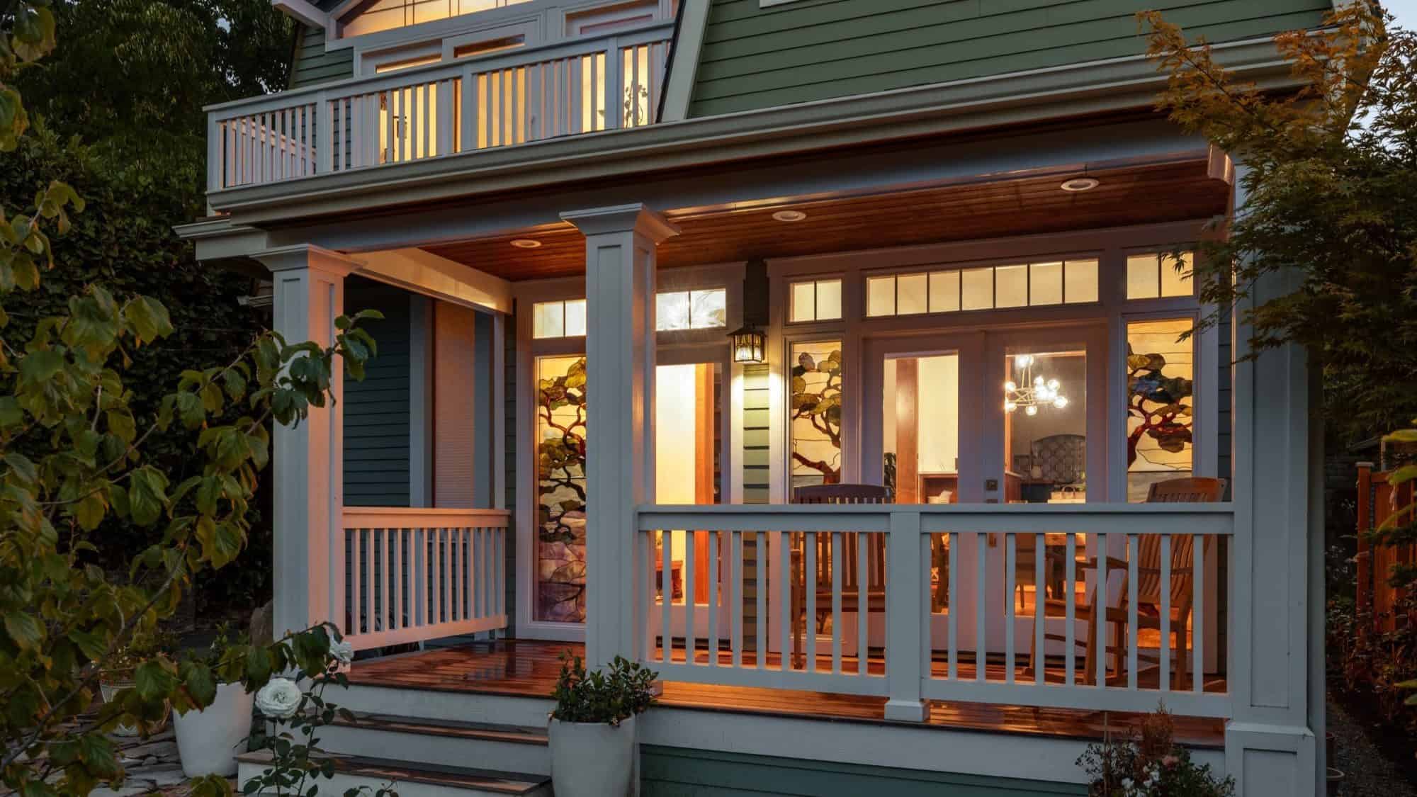 View of the front porch of a house located in Capitol Hill neighborhood in Seattle. The image was taking at night and the outside lighting reflects in the warm green pistachio color of the house.