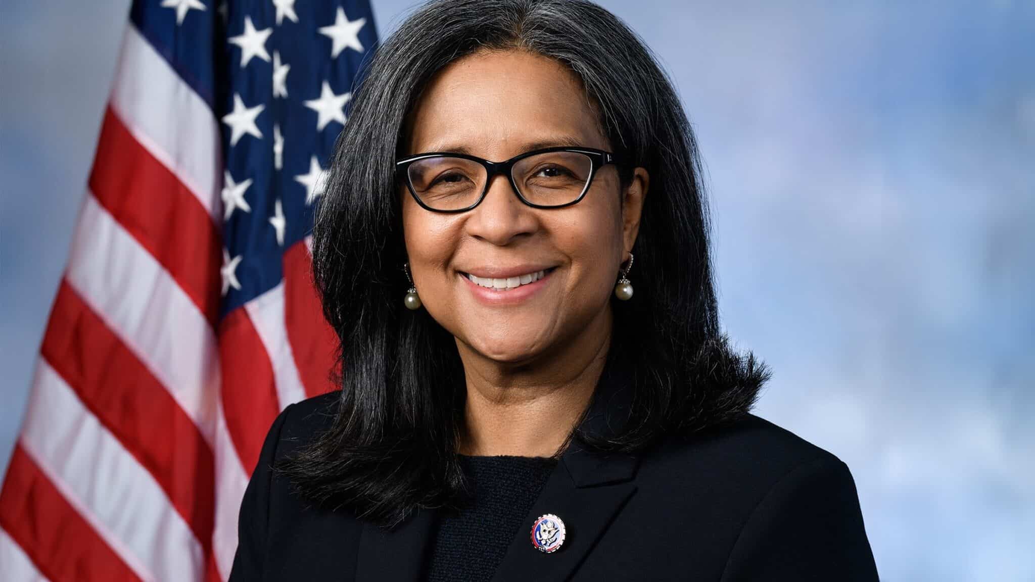 An official portrait of Marilyn Strickland smiling in front of an American flag.