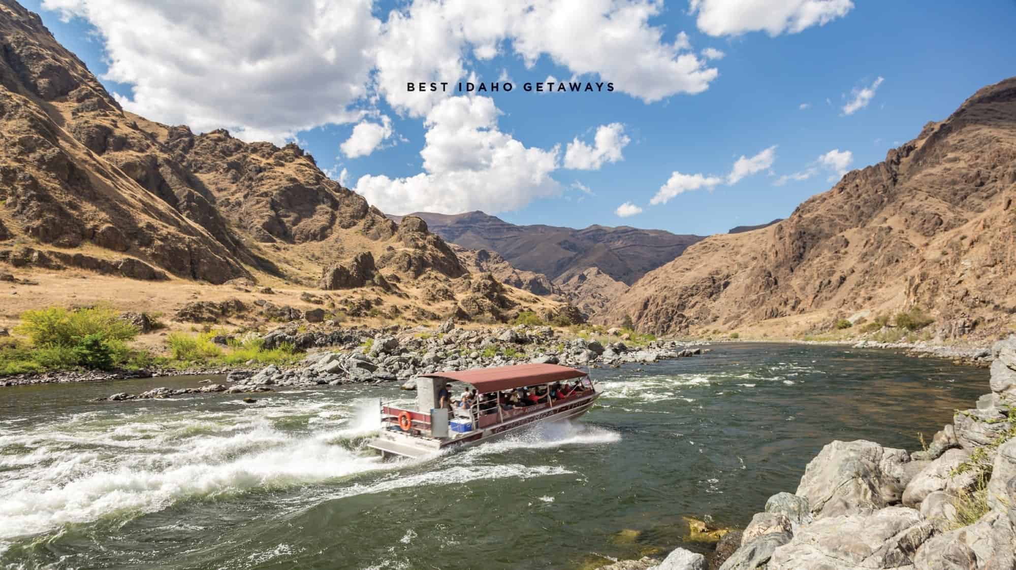 A tour boat navigates through rapids in a river surrounded by rocky, mountainous terrain in Idaho. Text on image reads "Iconic Idaho Getaways.