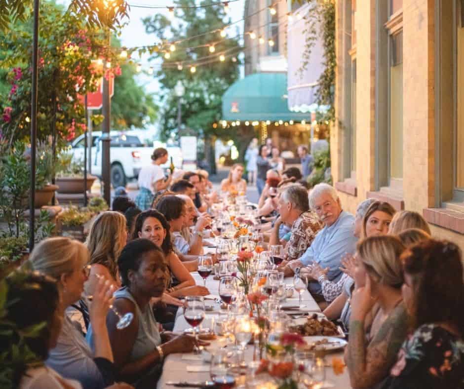 Diners enjoying an outdoor communal meal on a lively street at dusk in the hidden gem of Yolo County.